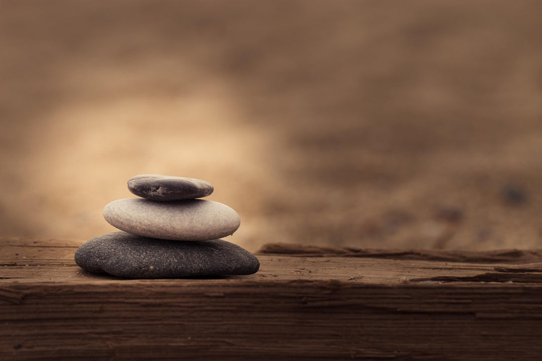 achtsamkeit-steine am see aufeinander gelegt